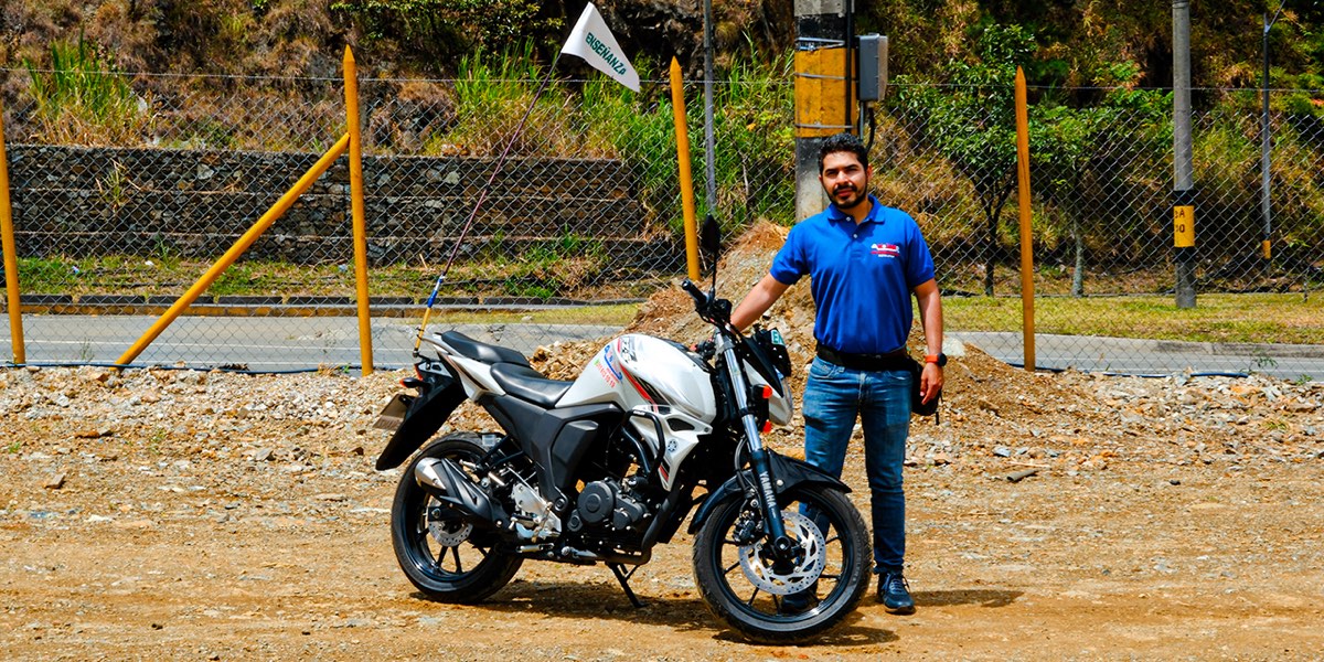 Instructor de Autolider junto a una motocicleta de enseñanza